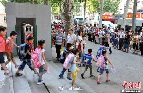资料图：学校门口，家长接孩子  中新社发 张畅 摄