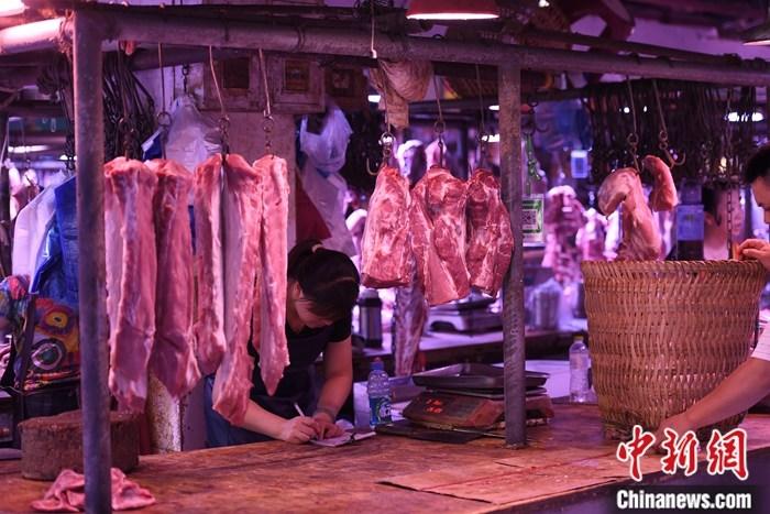 资料图为一农贸市场内的商家挂满充足的猪肉。<a target=