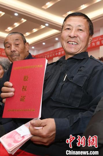 一位村民展示自己的股权证。　闵勇 摄