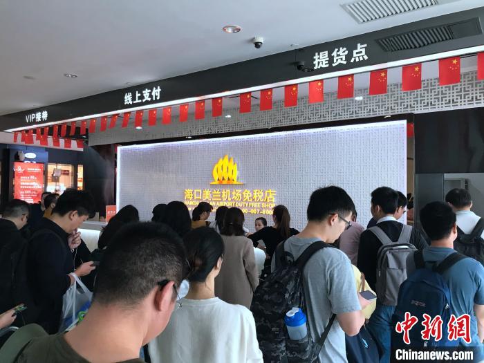 网购旅客在海口机场免税店提货点排队提货。　曾虹 摄