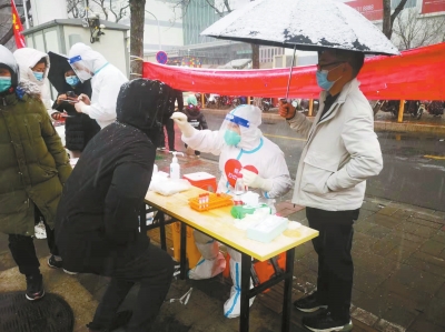 郑州迎来2022年的第一场雪 市民风雪中做核酸